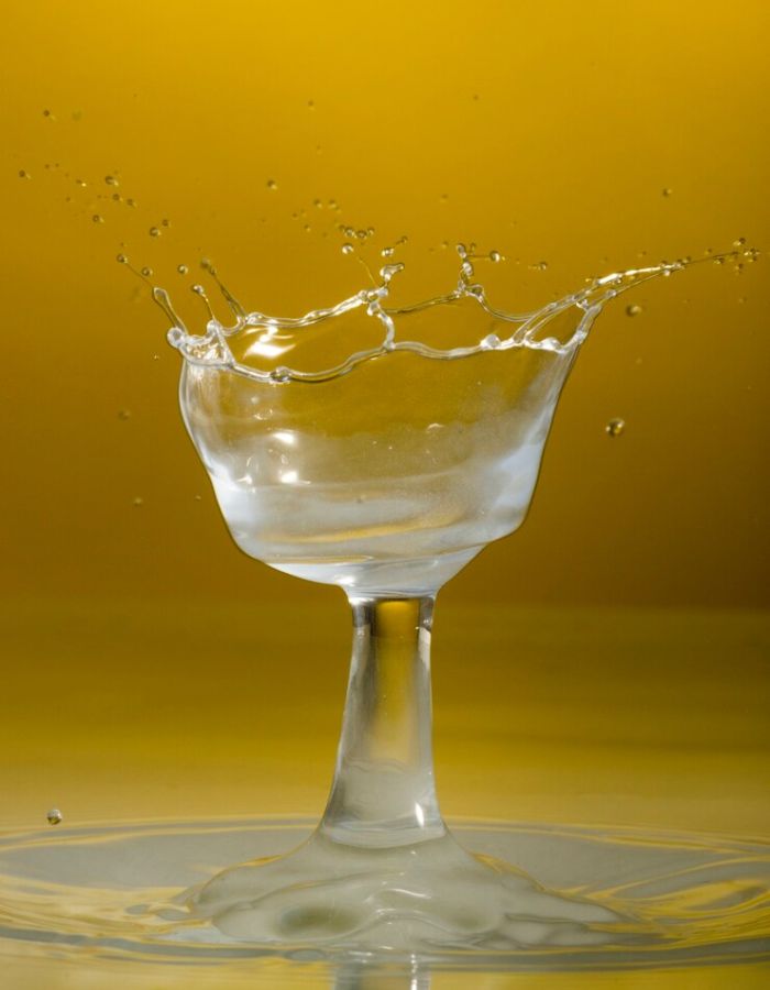 Artistic image of water splashing from a glass, representing neutral taste and solubility.